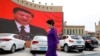 MUSLIMS-CAMPS/CHINA -- An ethnic Uighur woman walks in front of a giant screen with a picture of Chinese President Xi Jinping in the main city square in Kashgar in Xinjiang Uighur Autonomous Region, China September 6, 2018. 