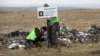 Dutch investigators place a sign near Malaysia Airlines Flight MH17 plane crash site